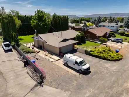 Aerial view of a ranch house with the van in the drive and job materials laid out