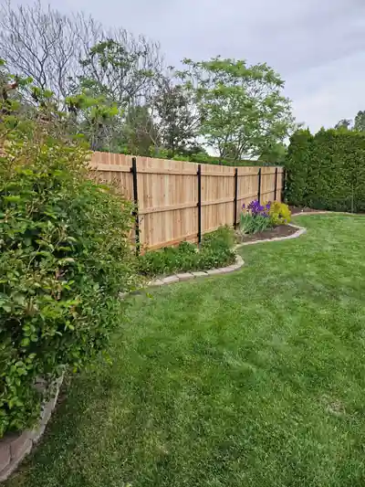 A cedar fence running alongside a garden bed