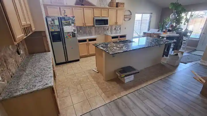A kitchen with a new granite-topped island, a Top Line remodel