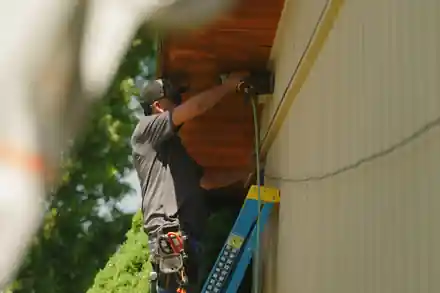 A painter on a ladder working the soffit