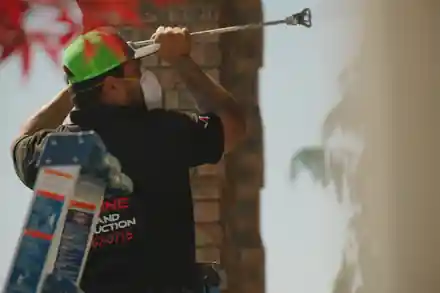 A painter spraying overhead in a Top Line shirt